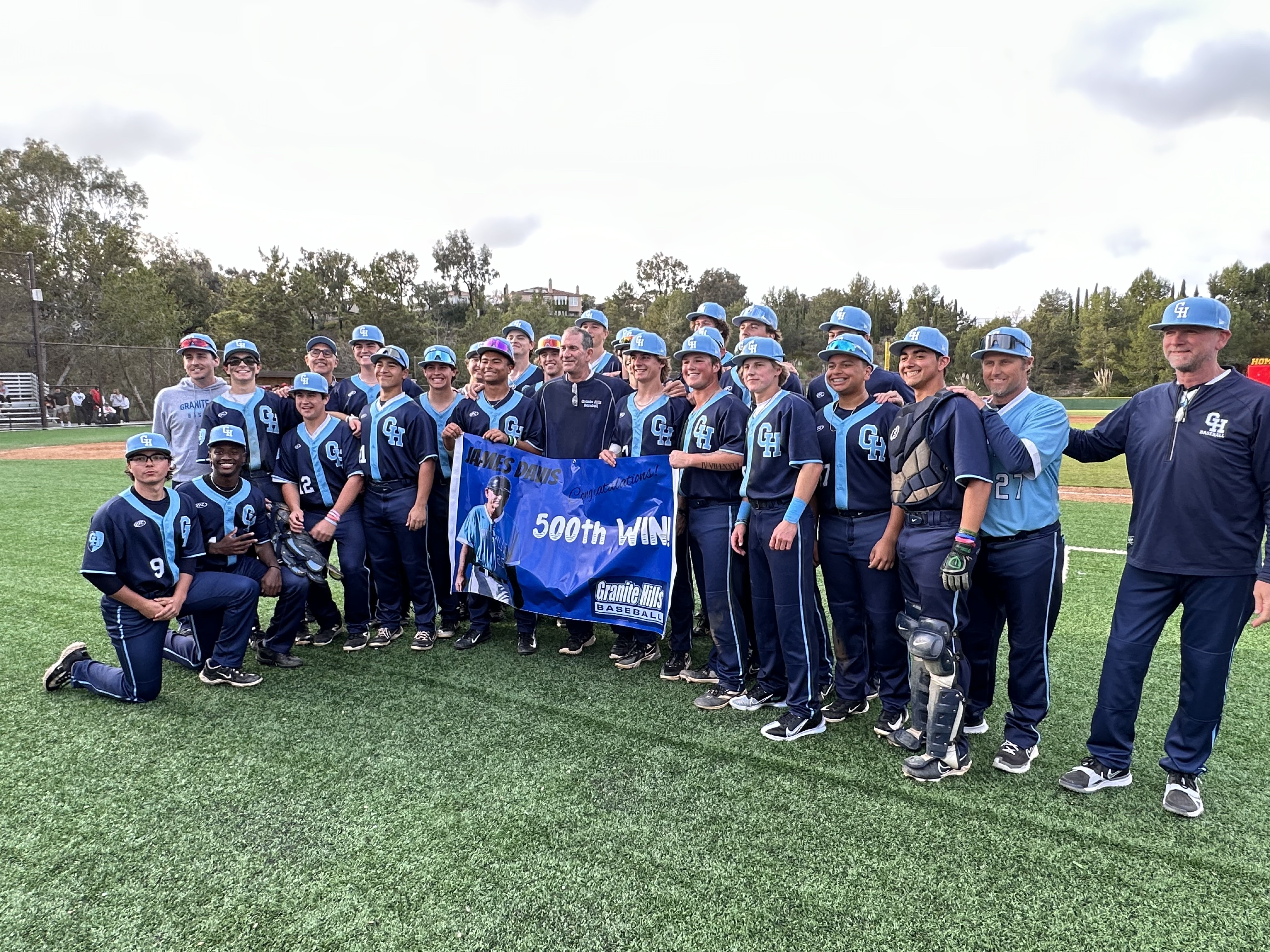 Granite Hills head coach James Davis celebrates with his team after picking up career victory No. 500 on Wednesday afternoon